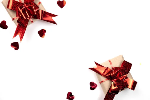 Fondo del Día de San Valentín. Caja de regalo hecha a mano decorada con confeti corazón rojo sobre fondo blanco. Estilo mínimo y concepto de día de San Valentín. Plano, vista superior, espacio para copiar — Foto de Stock
