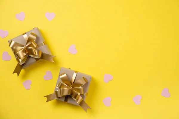 Valentin napi háttér. Két kézzel készített ajándékdoboz rózsaszín szív konfettivel díszítve, sárga háttérrel. Minimális stílus és Valentin napi koncepció. Lapos fekvés, felülnézet, másolás — Stock Fotó
