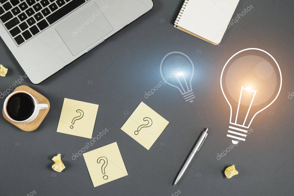 Question mark on sticky notes, notebook, cup coffee, light bulb image, phone, pen on gray background. FAQ concept. Working with clients. Troubles in work. Flat lay, top view, copy space