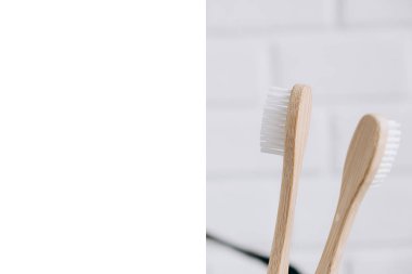 Çevresel bambu diş fırçaları ve beyaz arka planda çerçeve. Sürdürülebilir yaşam tarzı ve sıfır atık ev. Diş bakımı, çevre dostu ve yeniden kullanım konsepti. Boşluğu kopyala