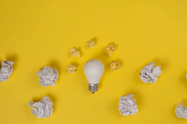 Nouveau concept d'idée avec papier de bureau froissé et ampoule blanche sur fond jaune. Solution créative pendant le concept de séance de remue-méninges. Pose plate, vue du dessus, espace de copie — Photo