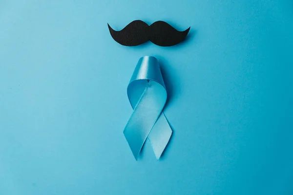 Fita azul clara com bigode no fundo azul. Cuidados de saúde, Homens internacionais, Pai e conceito Dia Mundial do Câncer. Flat lay, espaço de cópia — Fotografia de Stock