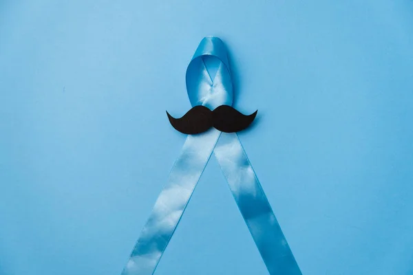 Vista superior na fita azul claro com bigode no fundo azul. Conscientização sobre o Câncer de Próstata, Movember Men 's health awareness, International Men' s Day — Fotografia de Stock