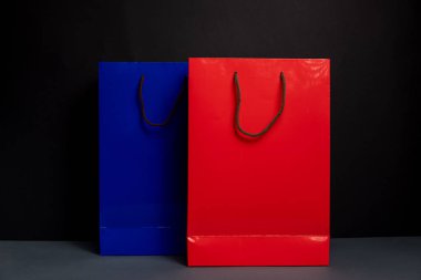 Siyah arkaplanda izole edilmiş iki renk alışveriş poşeti var. Paketleme şablonu modeli. Teslimat konsepti reklam taklidi. Alışveriş Konsepti