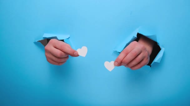 Kobieta Trzymająca Małe Białe Serduszka Przez Rozdartą Niebieską Ścianę Walentynki — Wideo stockowe
