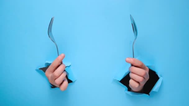 Female Hands Holding Spoon Fork Torn Blue Paper Wall Gesture — Stock Video