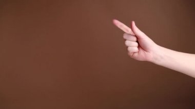 Closeup of female hand counting from to three and shows an ok sign on wall brown background. Hand sign. Body language and meditation concept.