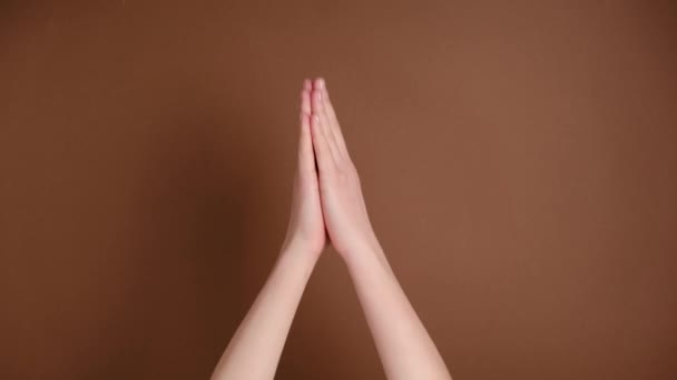 雌性手用交叉的手指祈祷 并在那之后为褐色的背景而高兴 身体语言的概念 广告区 模拟工作区 — 图库视频影像