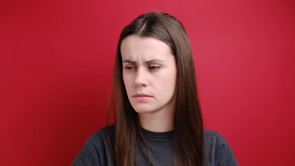 沮丧的年轻女子穿着灰色的T恤 穿着红色背景的衣服 在她的庙宇里露出手指枪口的姿势 消极的人类情感概念 — 图库视频影像