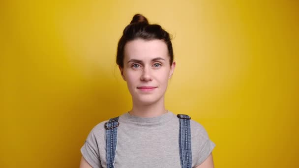 Mulher Retrato Camiseta Cinza Macacão Ganga Posar Fundo Amarelo Sorrindo — Vídeo de Stock