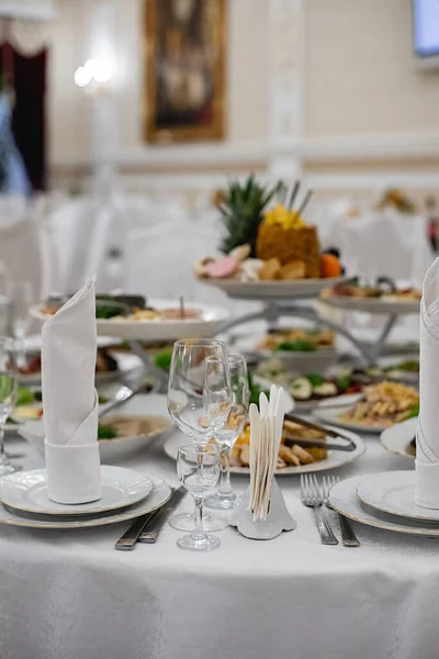 Server table plate knife fork and wine glasses at the banquet. Luxurious elegant dinner at the table in the restaurant. Holiday table decoration