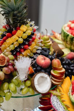 Şenlik masasını kapatın ananas, hindistan cevizi, üzüm, böğürtlen, karpuz, elma, nar ile farklı taze meyveler. Kutlama veya diğer olay