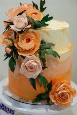 Pembe çiçeklerle süslenmiş güzel, modern düğün pastasının dikey görüntüleri. Parti ve tatil kutlaması konsepti