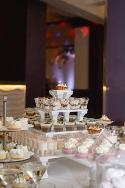 Düğün ya da doğum günü için tatlı masaları kapatın. İçinde bir sürü şeker ve tatlı kekler olan çikolata. Seçici odaklanma. Parti ve tatil kutlaması konsepti