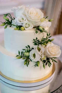 Beyaz çiçeklerle süslenmiş güzel, modern düğün pastasını kapat. Parti ve tatil kutlaması konsepti