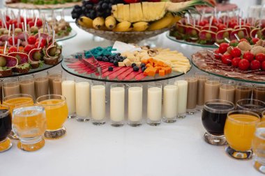 Soğuk aperatifler, kokteyller, soğuk etler ve peynirli büyük yemek seçeneklerinin yatay görüntüleri. Masanın üzerinde çeşitli lezzetli atıştırmalıklar var. Şirket doğum günü partisi ya da düğün kutlaması
