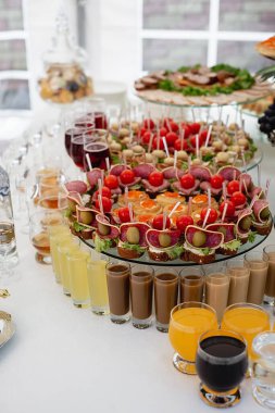 Masanın üzerinde çeşitli lezzetli atıştırmalıklar var. Soğuk aperatifler, kokteyller, soğuk etler ve peynirle geniş yiyecek çeşitlerini kapatın. Şirket doğum günü partisi ya da düğün kutlaması