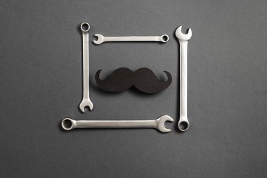 Babalar Günü modası geçmiş siyah, komik kağıt bıyıklı ve gri arkaplanlı ve fotokopi alanlı anahtar kombinasyonlu maketi. Düz konum, üst görünüm, minimal bileşim