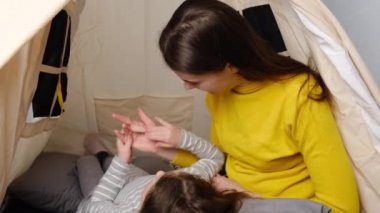 Mutlu bir anne ve küçük tatlı bir kızın çocuk odasında parmaklarıyla oynayıp sayması, birlikte eğlenmesi ve zaman geçirmesi.