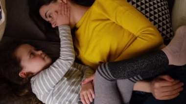 Mutlu bir anne ve küçük tatlı bir kız gülerek çadırda uzanıp eğleniyor, anne kucaklaşarak, evde küçük komik çocukla vakit geçirmekten hoşlanıyor. Kişisel tecrit, ev karantinası.