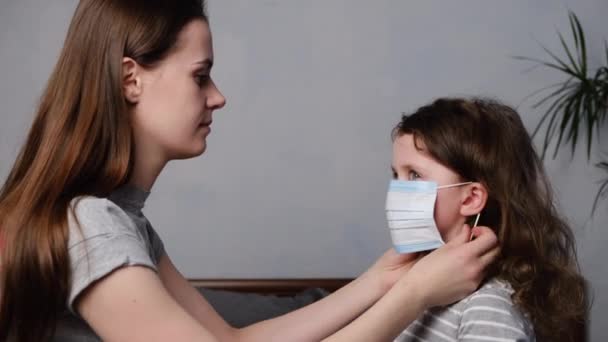 Mother Helping Her Daughter Dressed Virus Mask Sitting Bed Home — Stock Video