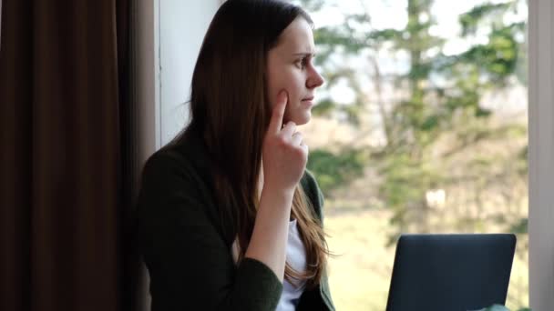 有思想的女性思考项目 做财务报告 使用笔记本电脑 坐在家里的窗台上 女性员工思考商业策略 解决问题 社会疏离 — 图库视频影像