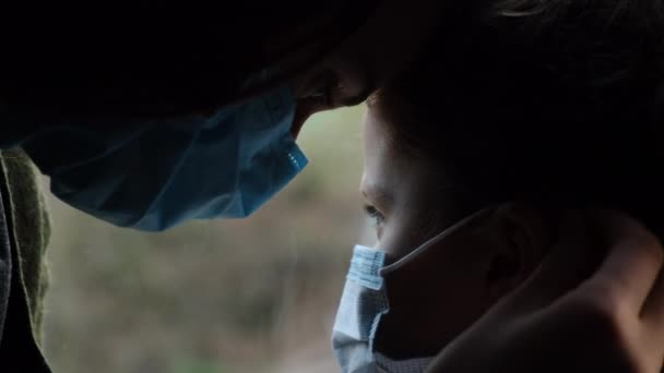 측면에서는 사람의 신뢰할 수있는 의료용 마스크를 창턱에 결합하는 모습을 보여준다 — 비디오