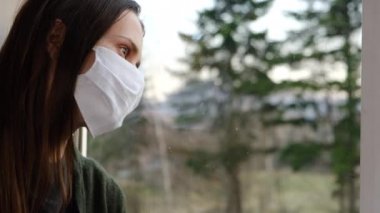 Tıbbi maske takmış sağlıksız bir kadının pencere pervazında oturması, Coronavirüs 'le öksürmesi, hapşırması, ilk kovid-19 semptomları, sağlık sigortası, korona konsepti.