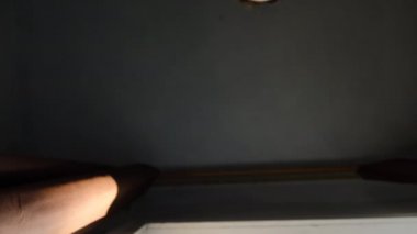 Tıbbi steril yüz maskesi takmış, hayal kırıklığına uğramış bir kızın düşük açılı görüntüsü stresi hisseder, ellerini pencere pervazına koyar, depresif kadın koronavirüsten muzdarip olur. Kişisel izolasyon, ev karantinası kavramı