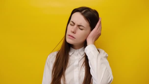 一个患有强烈耳痛的不健康的年轻女人的画像 紧张皱眉的女孩塞住耳朵 感到很不舒服 避免噪音 穿衬衫 穿黄色背景的模特 — 图库视频影像