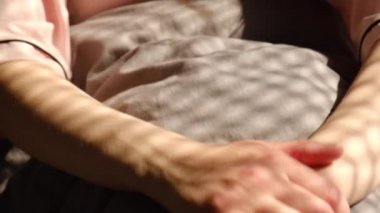 Kafkasyalı genç bir kadının portresi erken kalktıktan sonra pijama giyer. Dinlenmiş, dinlenmiş kız keyifli bir şekilde uyanır, rahat yatak odasında günaydın. Seçici odak