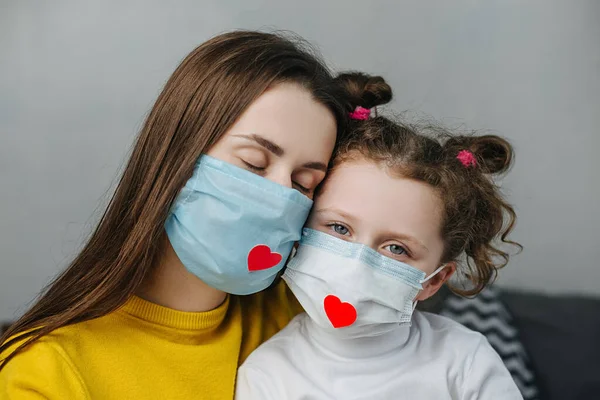 Cuidar Joven Madre Abrazar Pequeña Hija Linda Con Máscara Médica —  Fotos de Stock