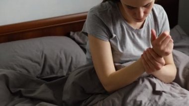 Elleri ya da bilekleri ağrıyan, bileği ağrıyan, bileğine dokunan, eklem ağrısı çeken, osteoartriti olan, eklem iltihabı olan bir kadın.