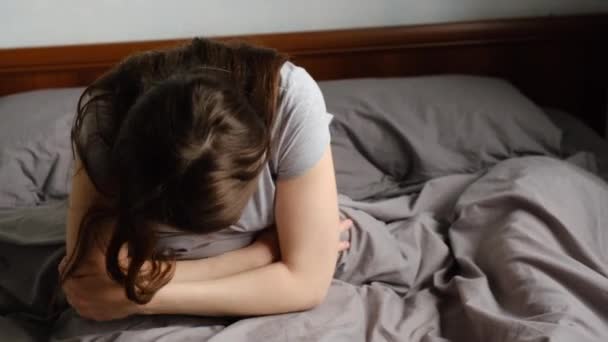 Расстроенная Молодая Женщина Сидит Кровати Дома Держа Живот Страдающий Боли — стоковое видео