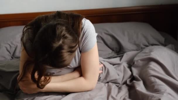 Jovem Perturbada Sentada Cama Casa Segurando Barriga Sofrendo Dor Estômago — Vídeo de Stock