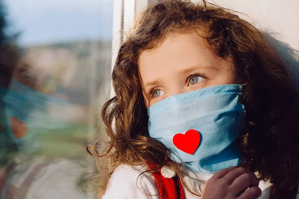 Πλευρική Άποψη Κοριτσάκι Φορώντας Προστατευτική Μάσκα Προσώπου Κόκκινη Καρδιά Κάθεται — Φωτογραφία Αρχείου