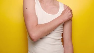 Sarı arka planda dikilen, boynu ağrıyan, omuz ve boynu ağrıyan, tanınmayacak kadar hasta, genç bir adam beyaz bir kıyafet giyiyor. Fibromiyalji kavramı