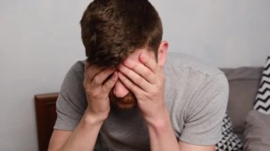 Mutsuz, yorgun, genç bir adam alnından el ele tutuşuyor, üzgün yalnız hissediyor yatakta yalnız başına oturup uyumaya çalışıyor, sorunları, korkuları, endişeleri ve umutsuzluğu düşünüyor. Psikolojik terapi, uykusuzluk.