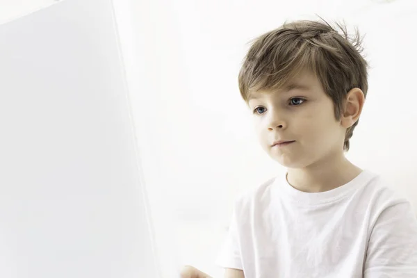 Een Jongetje Dat Thuis Aandachtig Naar Het Laptopscherm Kijkt — Stockfoto