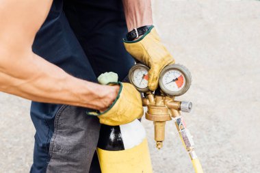 Sıkıştırılmış hava şişesi ve eldivenli itfaiyeci tarafından tutulan basınç göstergesi