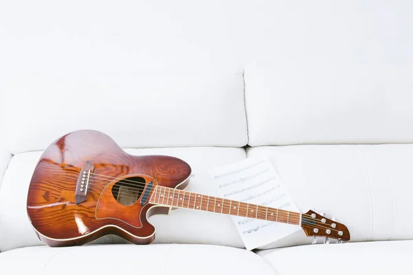 Akustikgitarre Und Noten Auf Weißem Sofa Und Weißem Hintergrund Kopierraum — Stockfoto