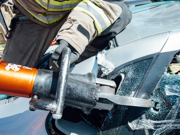 Brandman Använder Räddningsverktyg För Att Skära Fordon Räddning Genom Trafikolycka — Stockfoto