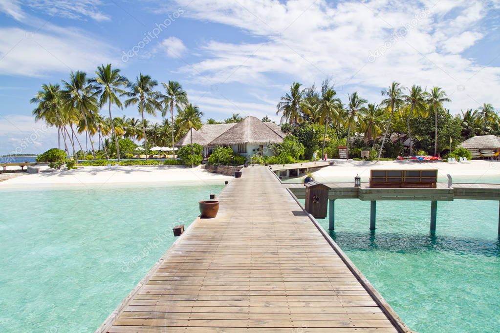 Wooden bridge to over water bungalow at luxury resort in Maldives 