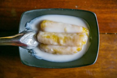 Tay tatlı Hindistan cevizi sütü ahşap masa üzerinde muz pişmiş