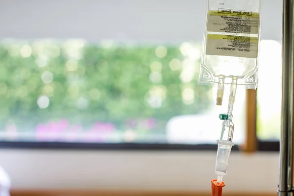 Saline bag and drip set for intravenous infusion for patient in modern hospital, selective focus on drip set