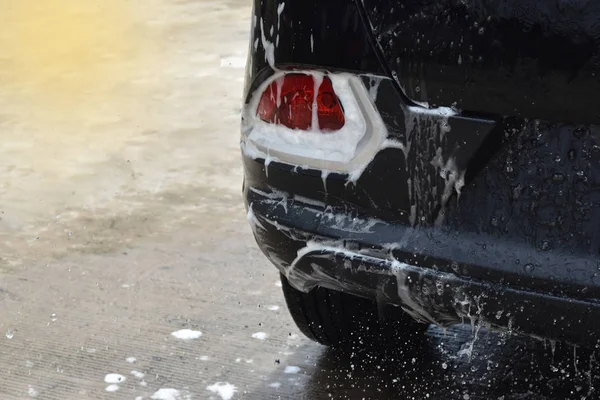 De staart lichten auto zwart, dat bubbels gevuld het gebied wassen . — Stockfoto