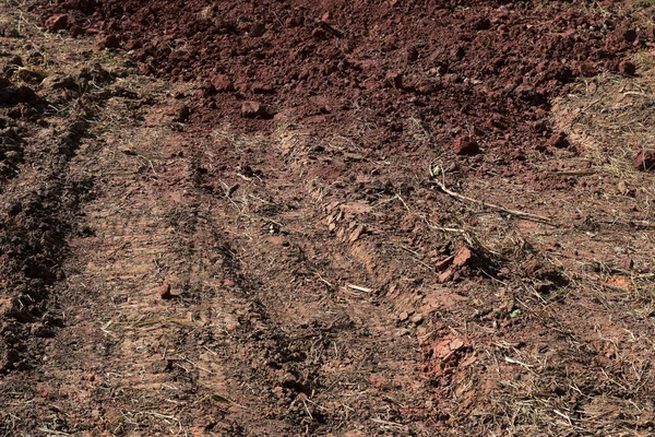 Sol brun rougeâtre avec et les roues du tracteur . — Photo