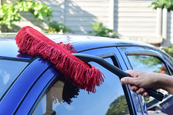 Man een blauwe auto schoonmaken. — Stockfoto