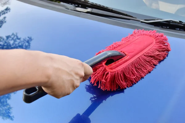 Hombre limpiando un coche azul , — Foto de Stock