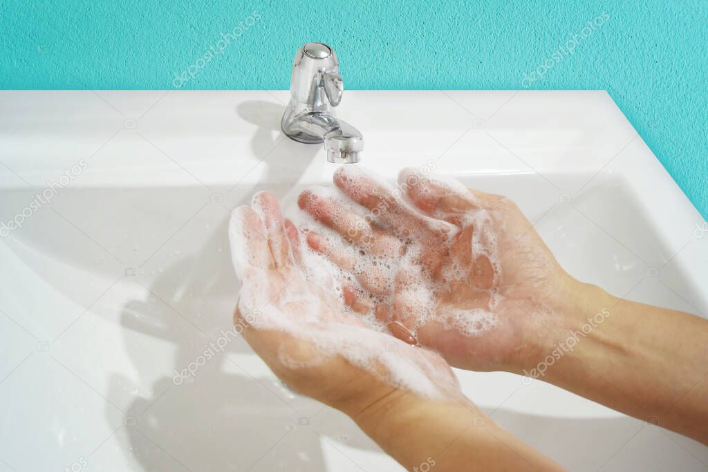 Person washing hands with water and soap in a sink. Protect coronavirus (covid 19) infection.